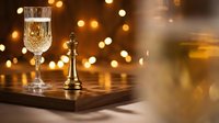 Elegant champagne glass and golden trophy on wooden surface with warm bokeh lights creating luxurious celebration atmosphere for awards ceremony.