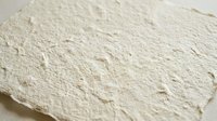 Handmade paper texture with natural fibers and organic surface for craft projects and artistic backgrounds.