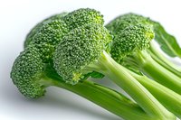 Fresh green broccoli florets with stems on white background, macro view showing detailed texture of vegetable. Clean eating and healthy food concept.