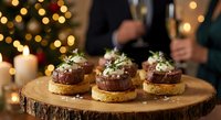 Gourmet beef sliders with microgreens on wooden board during festive dinner party with warm bokeh lights and candles creating cozy holiday atmosphere.