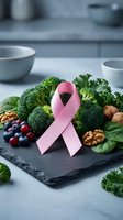 Pink ribbon with fresh broccoli, berries and nuts on slate board representing breast cancer awareness and healthy nutrition for prevention and recovery.