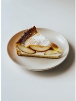 Fresh apple pie slice with powdered sugar on white plate against neutral background, showcasing layered fruit filling and flaky crust for food photography.