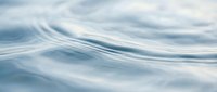 Soft flowing water waves with gentle motion blur creating serene abstract patterns, suitable for backgrounds and wellness designs.