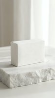 White rectangular box on natural stone platform with soft lighting for product display and branding mockup.