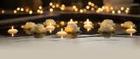 Spa wellness setup with white roses and glowing candles creating peaceful ambiance for relaxation and meditation sessions.