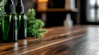 Green glass spray bottles with fresh herbs on wooden surface, selective focus creates atmospheric spa or wellness setting for cosmetic product photography.