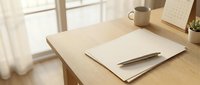 Minimalist wooden desk workspace with blank papers, pen and coffee mug in bright natural sunlight for productivity and planning concepts.