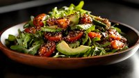 Fresh mixed greens salad with cherry tomatoes, avocado slices and balsamic glaze in wooden bowl for healthy dining and restaurant menu photography.