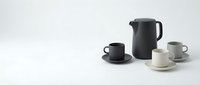 Modern minimalist coffee set with black pitcher and cups on white background for contemporary kitchen design and hospitality branding.