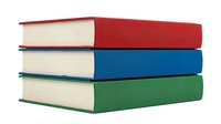 Stack of three closed books with red, blue, and green cloth covers and cream pages, isolated on white background, suitable for education, library, and publishing design projects.