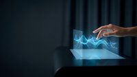 Hand touching holographic financial chart with glowing blue data visualization emerging from tablet screen in dark modern office environment.