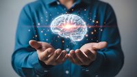 Professional man in blue shirt holding glowing brain hologram with neural network connections representing artificial intelligence and innovation.