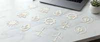 Wooden eco-friendly icons and symbols scattered on white marble desk with laptop and plant for sustainable business branding and design projects.