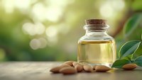 Natural essential oil in glass bottle with cork stopper and almonds on wooden surface with green bokeh background for aromatherapy and wellness.
