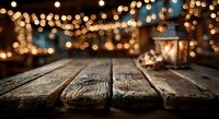 Empty wooden table surface with warm bokeh lights background for product display and festive holiday decorations in cozy indoor setting.