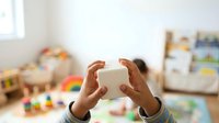 Young child with medium skin tone holding white building blocks, engaging in developmental play and learning activities in a colorful playroom environment.
