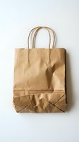 Brown kraft paper shopping bag with twisted handles isolated on white background for retail packaging and eco-friendly branding projects.