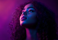 Young African American woman with natural curly hair in dramatic purple and blue neon lighting, looking up with parted lips, creating atmospheric nightclub mood.
