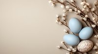 Pastel blue Easter eggs and speckled egg with cotton branches on beige background, spring holiday composition with copy space for text or design.
