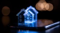 Glowing blue house silhouette on dark background with bokeh lights, digital device screen reflection creates magical miniature home atmosphere.