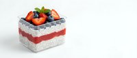 Layered chia pudding dessert with fresh strawberries and blueberries in glass container on white background, healthy breakfast parfait isolated.