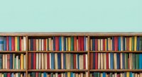 Library bookshelf with colorful books arranged on wooden shelves against mint green wall for educational and literary design projects.