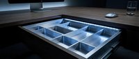Modern kitchen drawer with LED lighting system showcasing organized compartments for utensils and cutlery storage in contemporary home interior design.