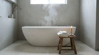 Modern minimalist bathroom interior with freestanding white oval bathtub, wooden stool with rolled towels, steam rising from hot water, concrete walls, and natural skylight for spa relaxation and home design.