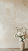 White roses in ceramic vase against neutral beige textured wall background. Minimalist floral composition on wooden surface creates serene atmosphere.