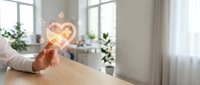 Young woman with light skin tone holding glowing heart-shaped neon sign in modern home office, symbolizing love, passion, and positive energy for wellness and lifestyle content.