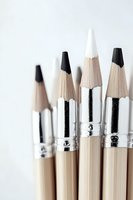 Sharp wooden pencils with silver metal bands arranged in minimal composition against white background, emphasizing clean lines and artistic tools.