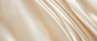 Smooth cream silk fabric with soft folds and luxurious sheen, suitable for fashion, textile, and luxury product design backgrounds.