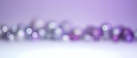 Purple bokeh lights background with soft blurred circles and white surface for product display and holiday decorations.