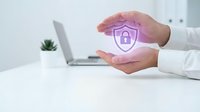 Professional hands holding glowing purple shield with padlock icon, symbolizing cybersecurity protection and data safety for business and technology concepts.