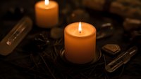 Burning candles with tarot cards and crystals creating mystical atmosphere for fortune telling and spiritual practices.