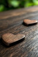 Rustic wooden hearts on dark textured table with soft natural lighting and shallow depth of field create romantic vintage atmosphere for Valentine's day designs.