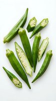 Fresh green okra pods whole and sliced showing seeds isolated on white background for healthy cooking and organic vegetable recipes.