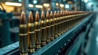 Rows of brass ammunition bullets lined up on industrial production line with selective focus and bokeh background, showcasing military or hunting supplies.