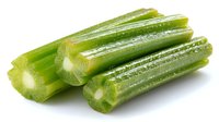 Fresh cut celery stalks with crisp texture and vibrant green color on white background, ready for healthy eating or cooking preparation.