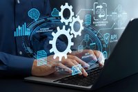 Business professional using laptop with digital technology gears and data analytics interface overlay for automation and system development processes.