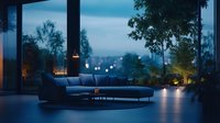 Modern luxury living room with panoramic windows overlooking evening cityscape, blue velvet sofa, ambient lighting and minimalist interior design at dusk.