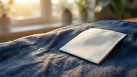 White blank fabric label on denim jeans with warm sunlight streaming through window creating soft shadows and cozy domestic atmosphere for branding mockup.