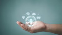 Young adult male hand holding glowing holographic globe with digital icons representing global business, technology, and connectivity concepts against teal background.