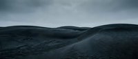 Dark moody landscape with rolling hills under stormy cloudy sky creating dramatic atmospheric scenery for environmental and nature projects.