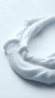 Creamy white whipped texture with soft swirls and peaks, isolated on light background. Suitable for cosmetics, skincare, dairy and food packaging design.