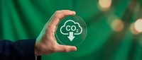 Hand holding a glass circle with CO2 reduction cloud icon on green background, symbolizing carbon neutrality and climate action.