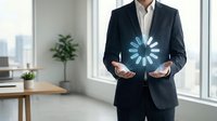 Caucasian male professional in dark business suit and white shirt holding glowing blue digital loading icon in modern office with city skyline view, representing technology, progress, and business innovation.
