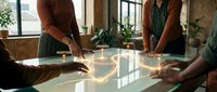 Business professionals analyzing data with digital holographic charts and graphs projected above conference table in modern office meeting room.