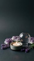 Zen spa composition with burning candle, amethyst crystals, lavender flowers and glass sphere on dark background for wellness and meditation practices.