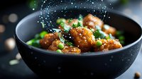 Glazed meatballs with green peas in black bowl with flying spice particles. Fresh cooked dinner meal with sauce and vegetables for restaurant menu design.